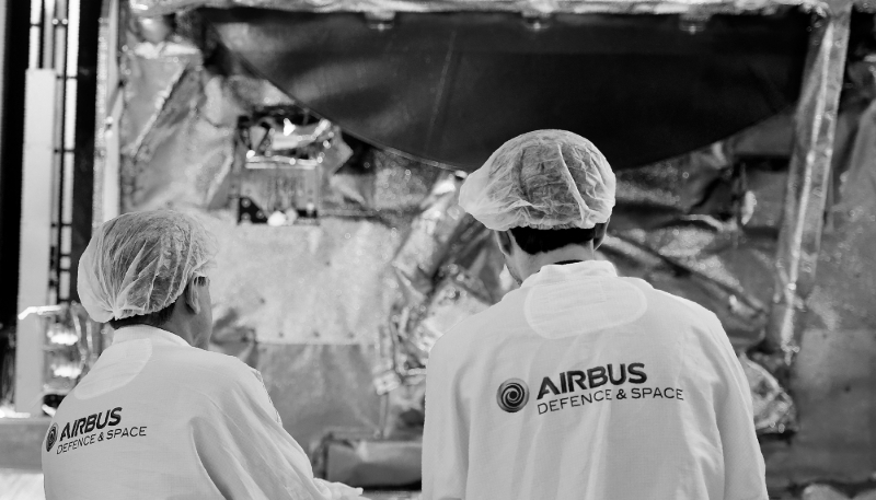 Des ingénieurs devant un satellite au siège d'Airbus Defense and Space, à Toulouse.