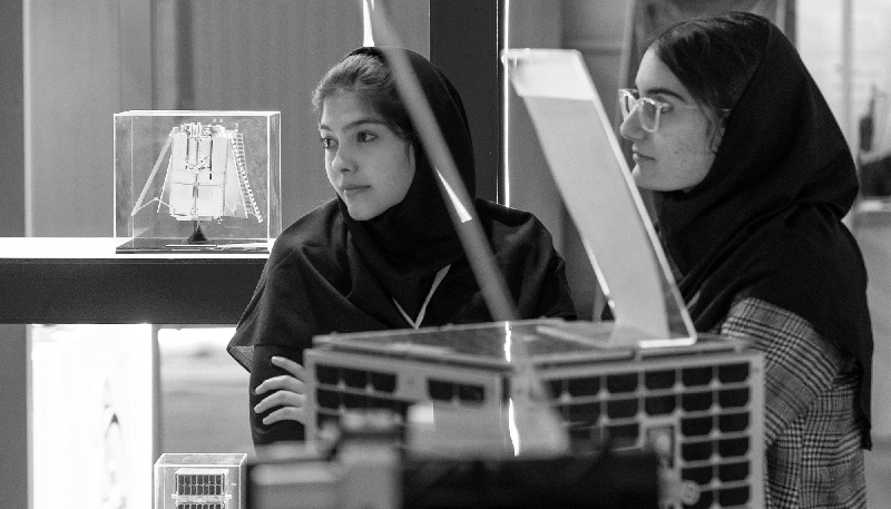 Deux jeunes scientifiques iraniennes sur le stand de l'Iranian Space Research Center durant une exhibition à Téhéran, le 11 février 2025.