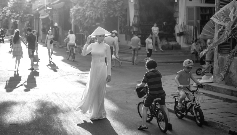 Femme portant le traditionnel áo dài dans une rue de la vieille ville de Hoi An, Vietnam.